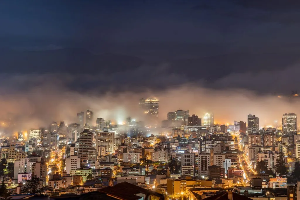 Downtown Quito at night time with building lights and fog.