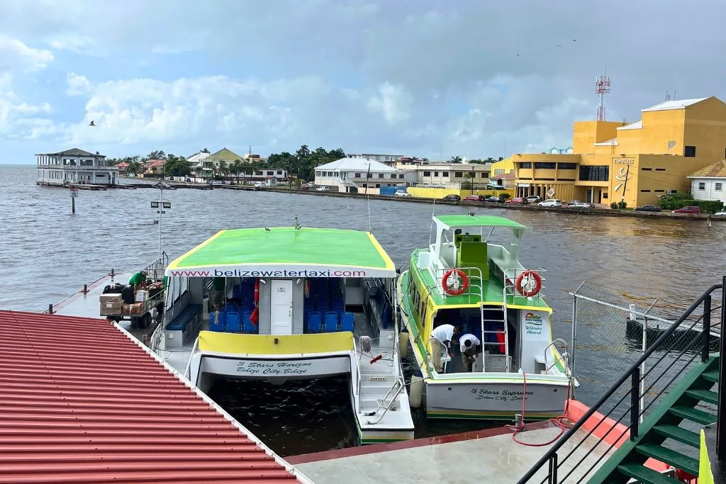 Two Belize water taxis docked at the terminal in Belize City. In the background you can see the Bliss performing arts center.