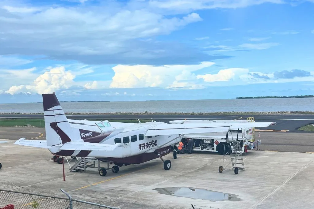 A Tropic Air plane is being fueled up on the runway.